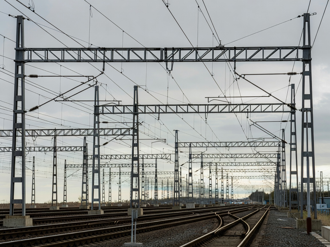 Complex array of overhead line equipment cables and steel stanchions above a railway junction